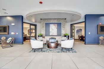 A modern living room with a fireplace and a large painting above it.